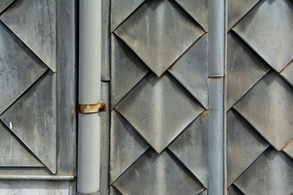 Close-up of a geometric metal wall pattern with rust and texture, showcasing industrial design elements.